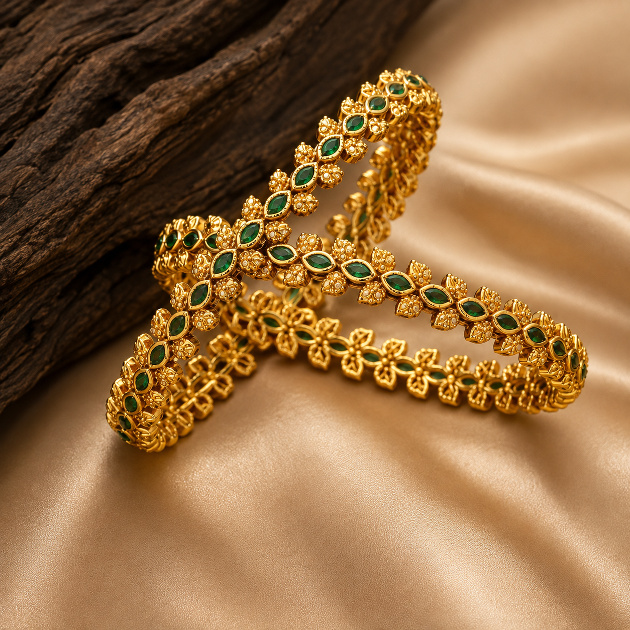 Latest Gold Bangle Designs That Define Timeless Elegance These gold bangles have green leaf stones and fine floral details for a rich traditional jewelry look.