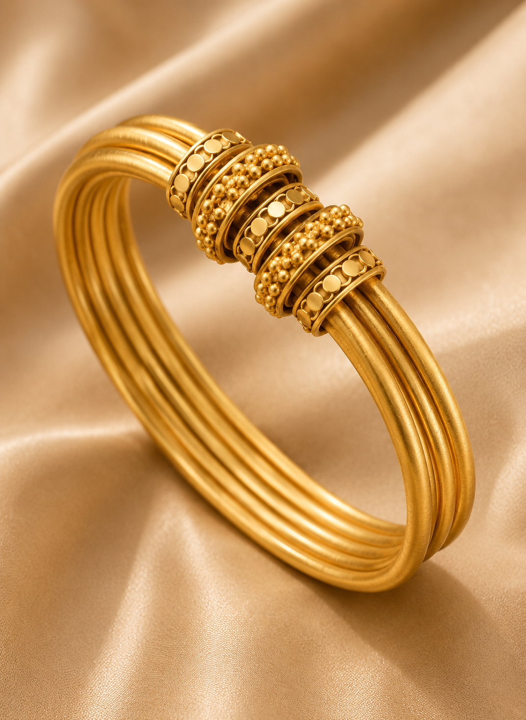 Latest Gold Bangle Designs That Define Timeless Elegance Layered Gold Kada: This layered gold kada has smooth round bands with rich bead and disc details for a bold traditional jewelry look.